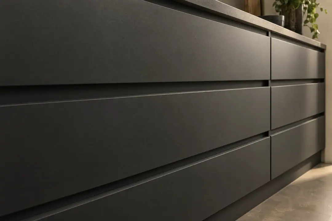Matte charcoal drawer fronts aligned with narrow, even gaps in raking light